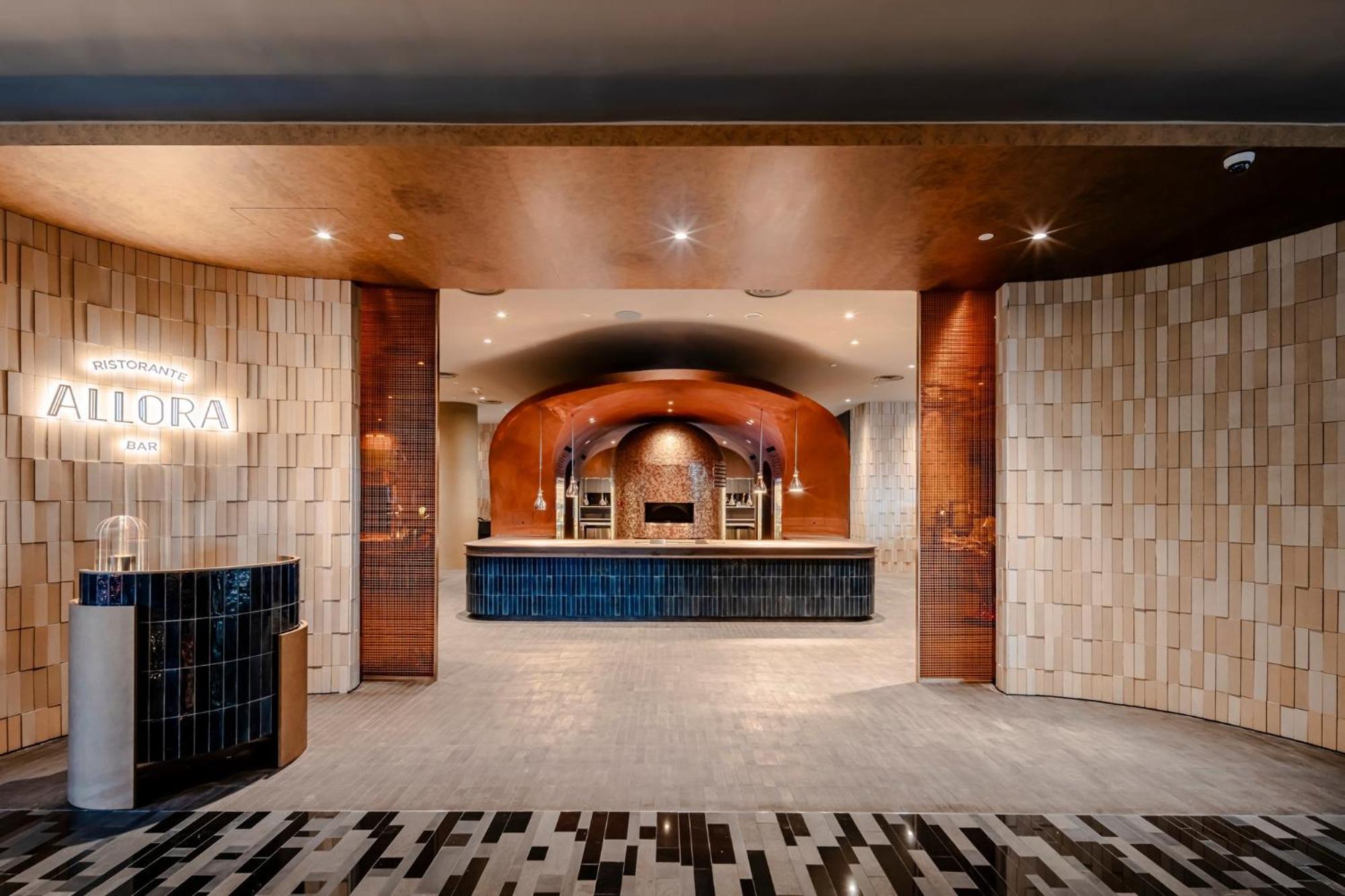 Crowne Plaza Changi Airport By Ihg Σιγκαπούρη Εξωτερικό φωτογραφία The photo shows a modern reception area, characterized by a stylish and elegant design. The space features a combination of textured wall panels, including light-colored tiles and warm-toned materials. In the center, there is a sleek reception desk a