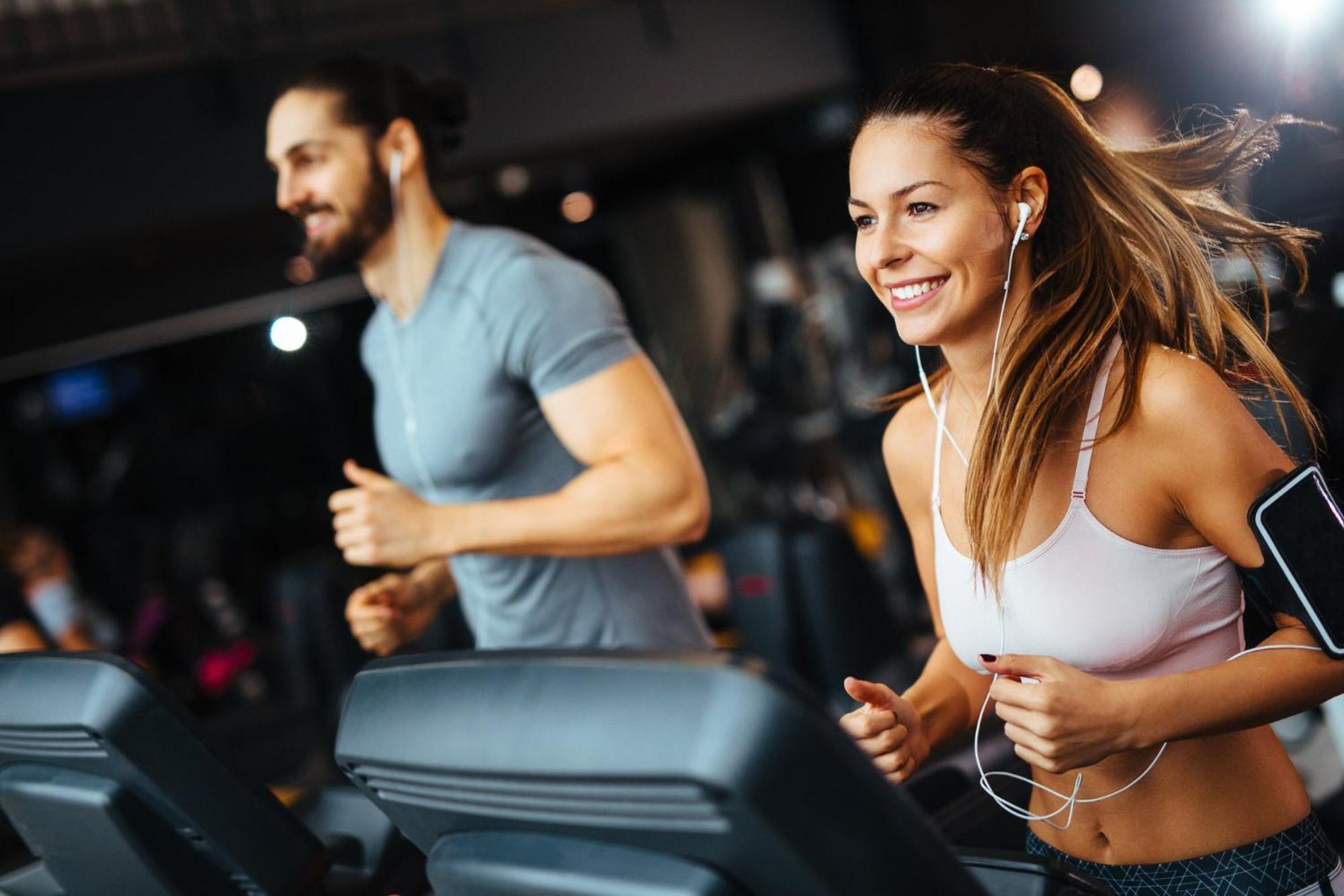 Crowne Plaza Changi Airport By Ihg Σιγκαπούρη Εξωτερικό φωτογραφία The photo shows two individuals running on treadmills in a gym. The woman, wearing a sports bra and workout leggings, has earbuds in and is smiling as she runs. The man, next to her, wears a fitted t-shirt and appears to be focused on his workout. Bo